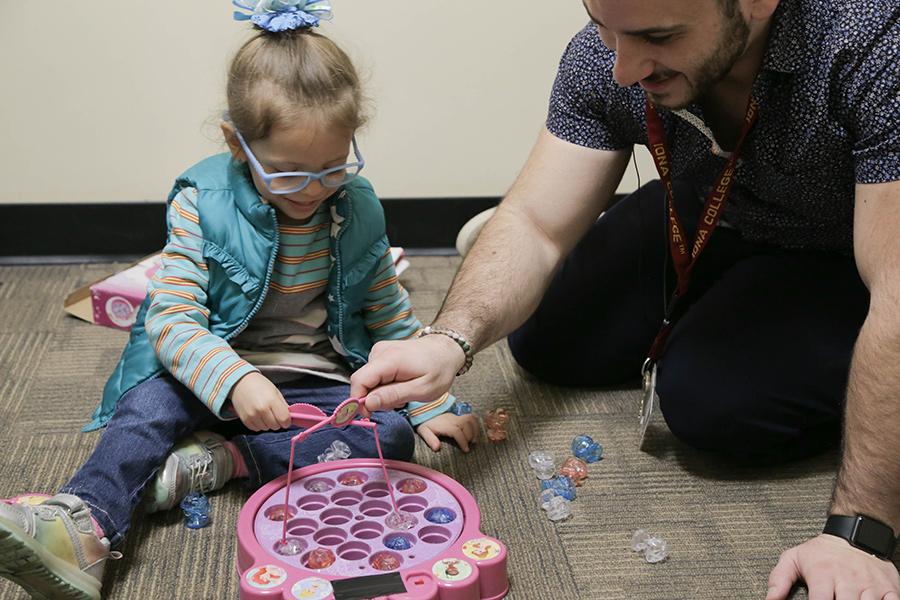 A Speech and Hearing Clinic staff member works with a child.