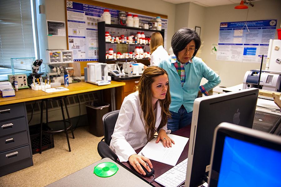 Dr. Sunghee Lee works looks at data on a computer with a student in the lab.