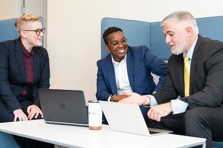 Three MBA students work on a project together in the common space.