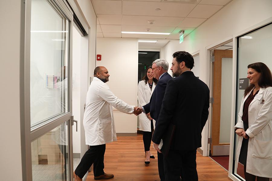 Al Kelly shaking hands with a nursing professor.