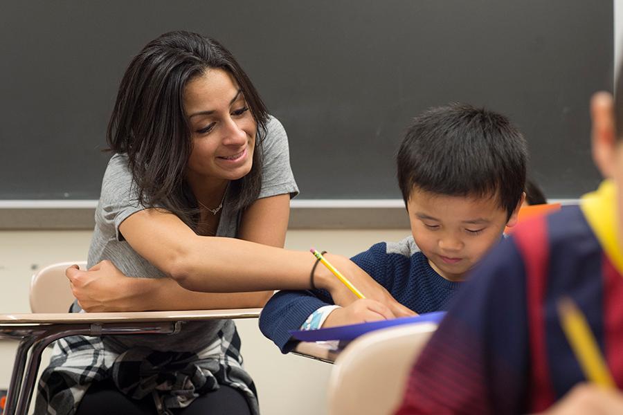 A Literacy specialist helps a student with his writing.