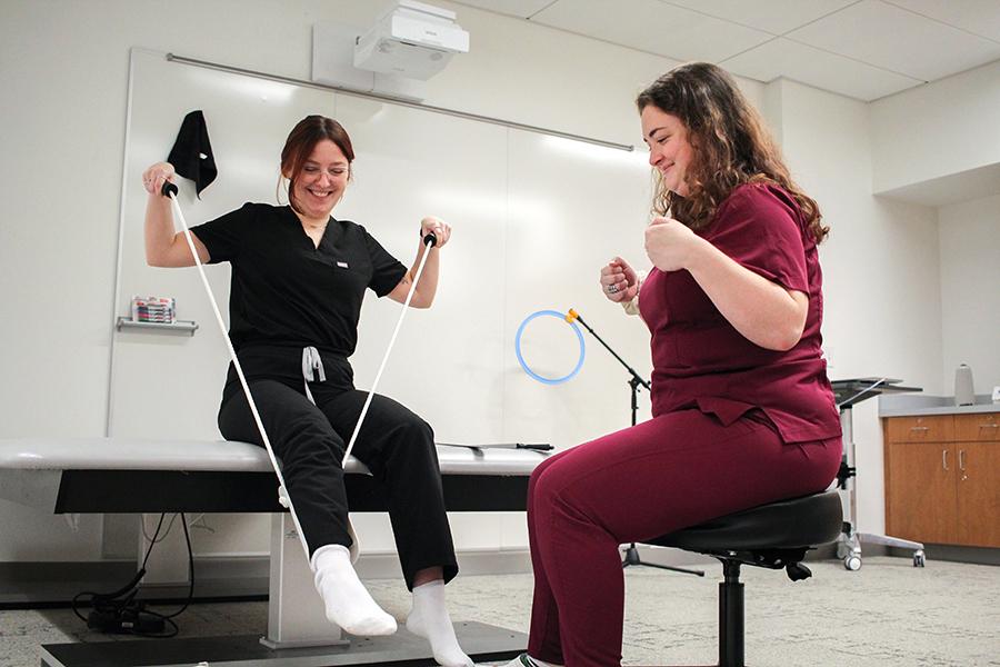 OT students practice helping a client put on a shoe.