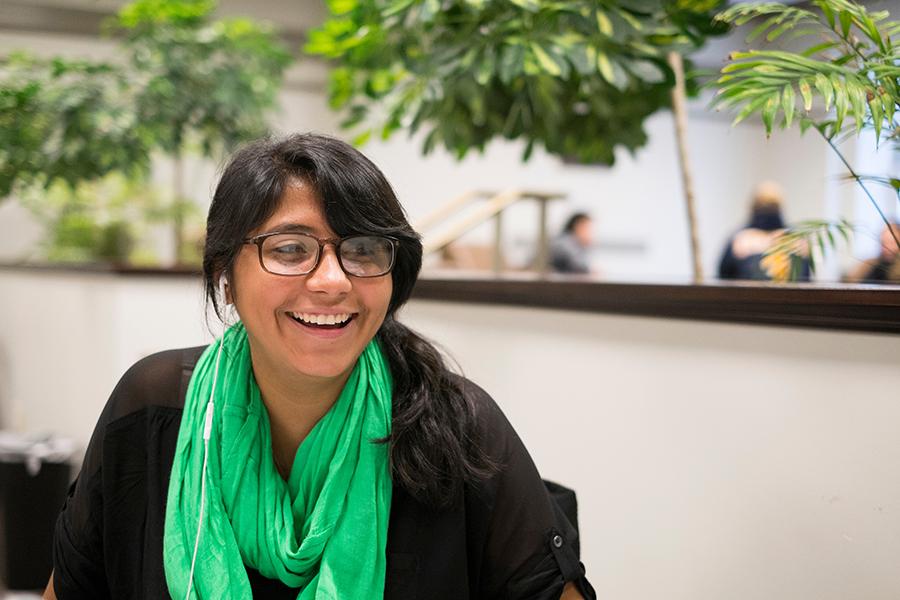 A student in a green scarf smiles.