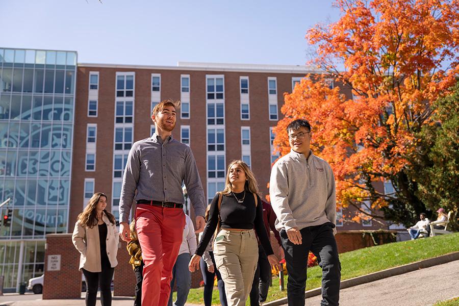 Three students enter campus through the north avenue entrance.