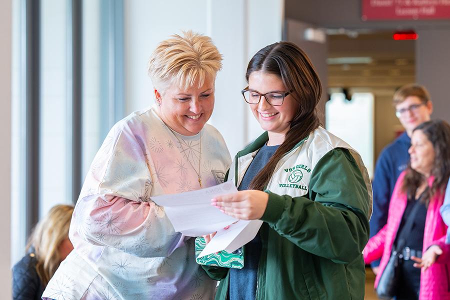 A mother goes over the new student checklist with her daughter.