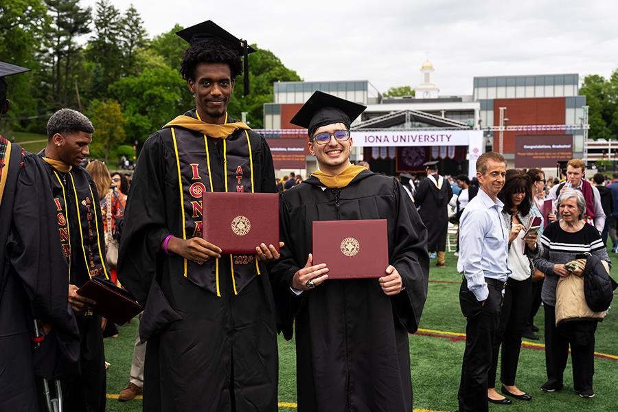 Oz Shema and his friend hold their degrees. 