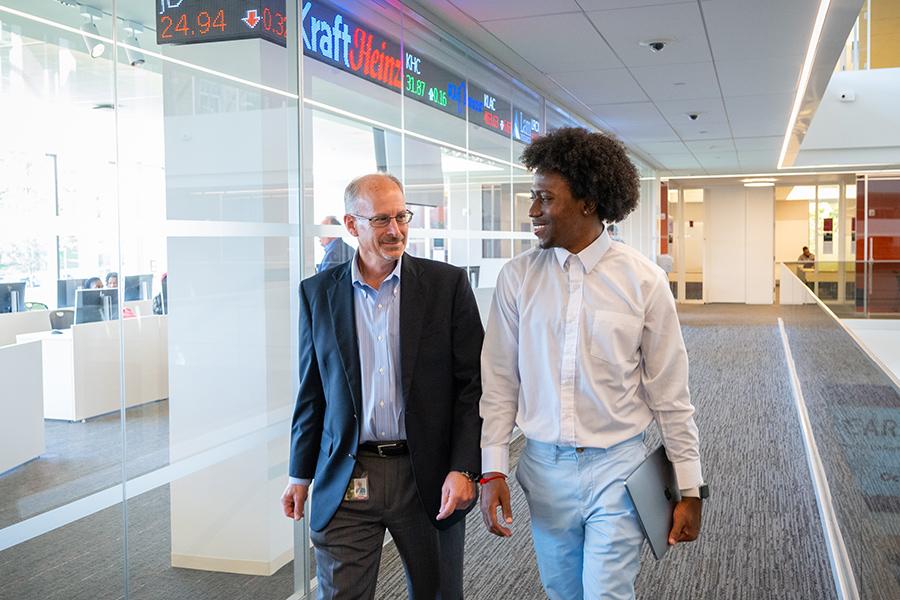 Dean DeMelis and a student walk near the trading floor.