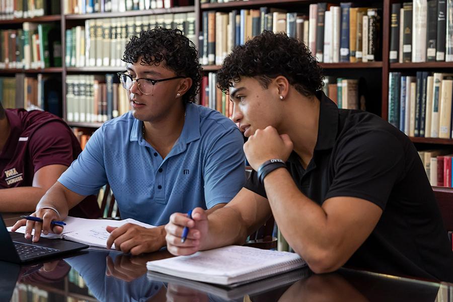 Two students study ethics in the library.