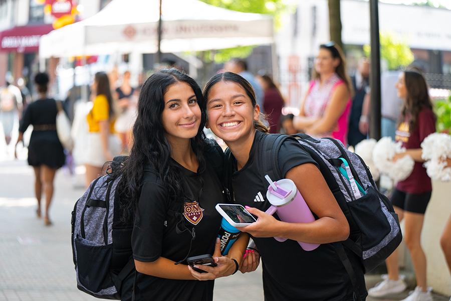 Two students smile warmly at move-in day.