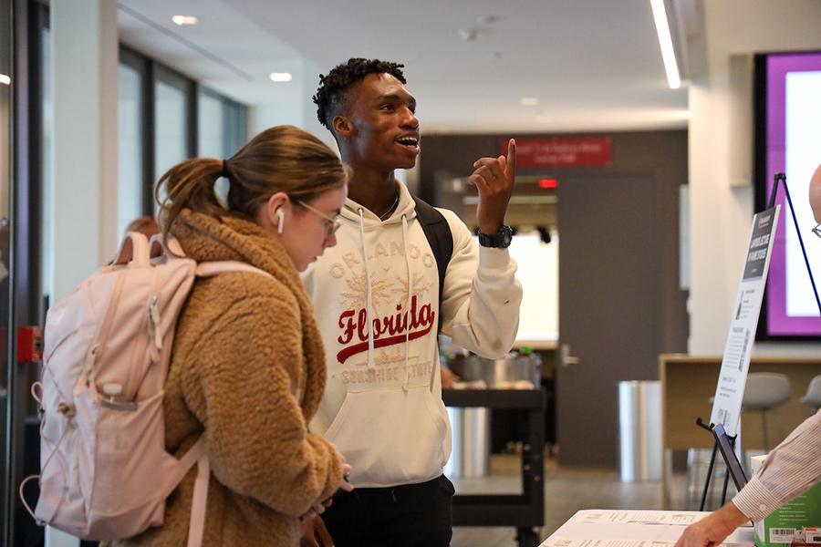 Two students ask questions at the voting event.