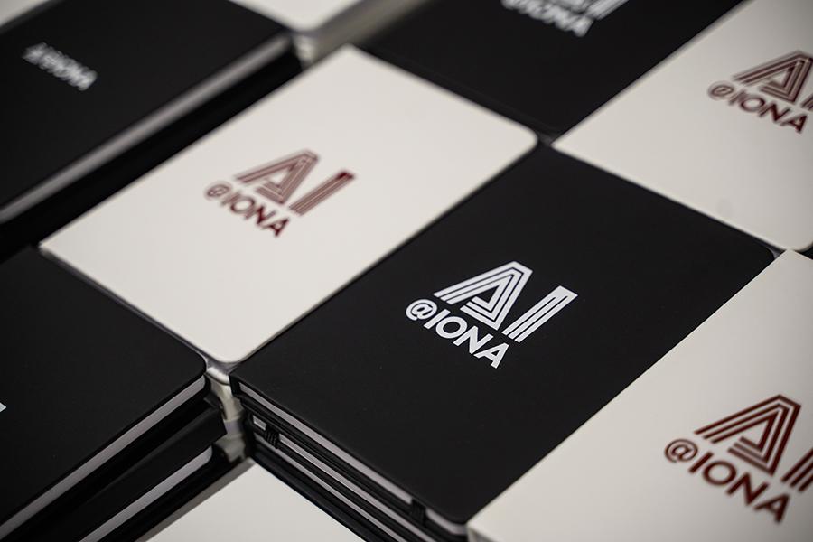 AI@Iona notebooks stacked on a table.