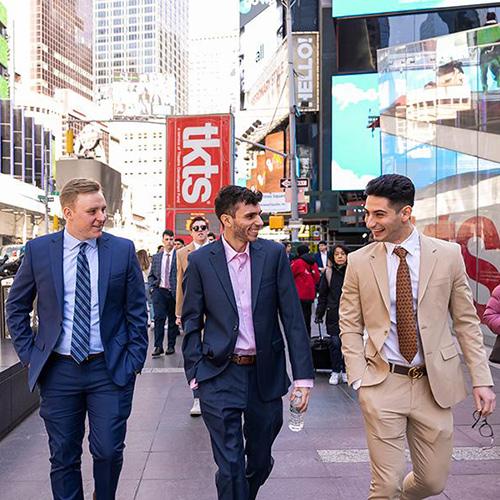 Three students walk in Times Square.