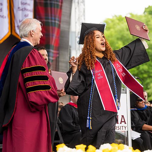 A student celebrates her degree at Commencement.