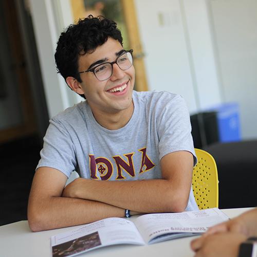 An undergraduate student in an Iona shirt smiles.