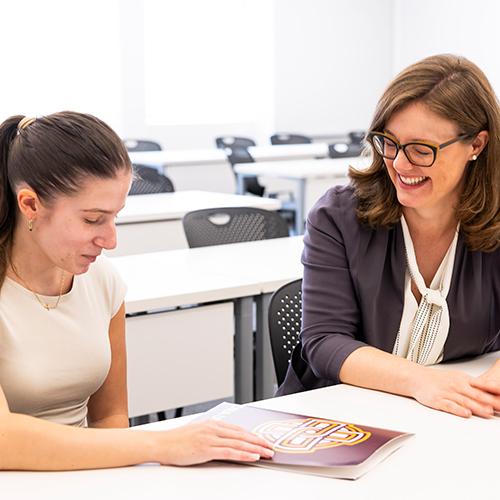 A student and professor work together in a classroom.