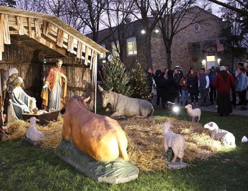 Members of the Iona Community gather around the Chreche to ring in the holidays and sing.