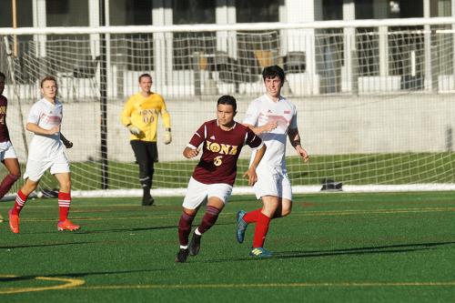 Iona men's club soccer run down field.