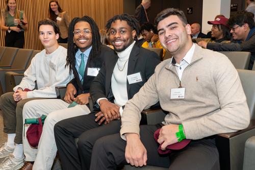 Four students sit in the hall at the mentoring party.