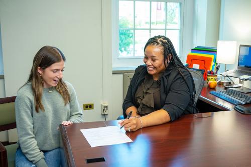 A student and an advisor review a document.