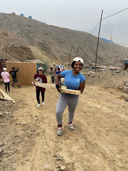 Students help carry lumber in Lima, Peru.