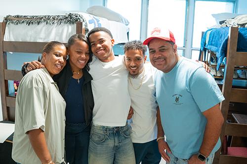 A family of five moves their son into a dorm room.