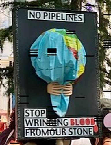 A protestor holding a No Pipelines sign.