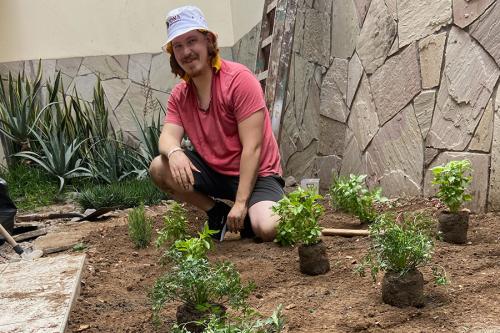 An Iona student works in a garden as part of service-learning.