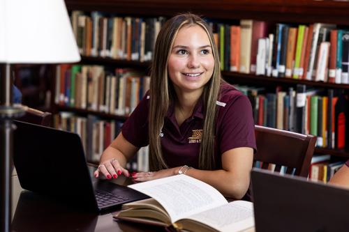 A student athlete smiles in the library.