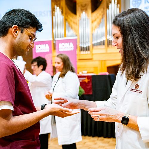 A nursing student has his hands blessed.