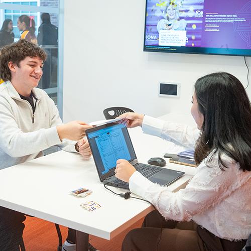 A transfer student accepts his letter from an admissions counselor.