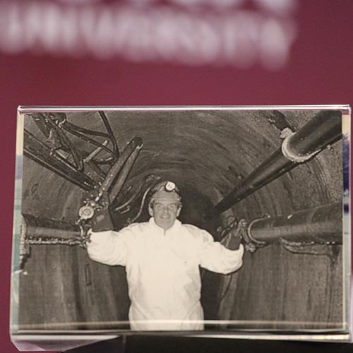 A black and white photo of Jim Hynes working in a tunnel with communication lines.