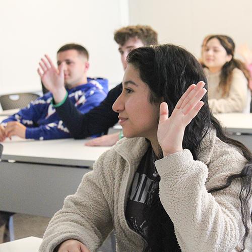 A student raises her hand in class.