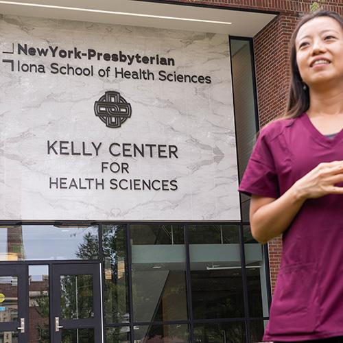 An OT student stands in front of the Kelly Center for Health Sciences.