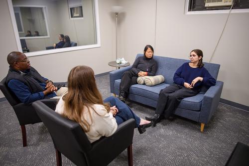 Therapists work with a couple in the MFT clinic room.