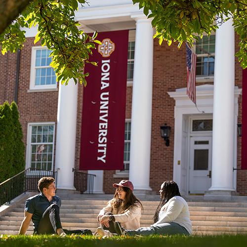 Students sit and talk outside of McSpedon Hall.