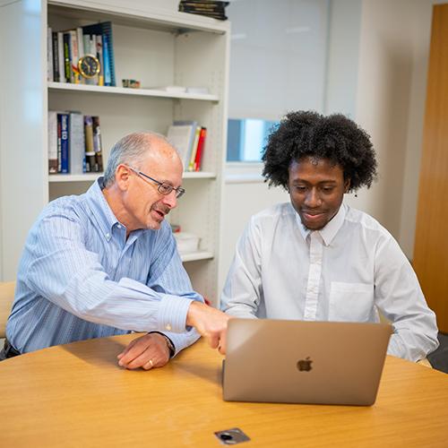 A business professor works with a student.