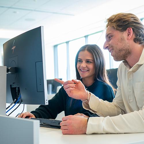 Two students work at a computer in the LaPenta School of Business.