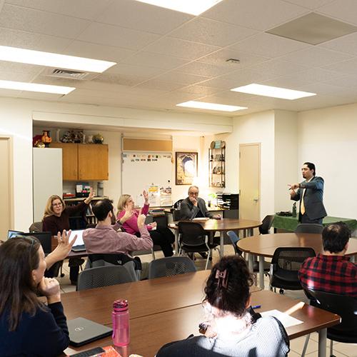 A professor working with teachers in Bronxville at an AI workshop.